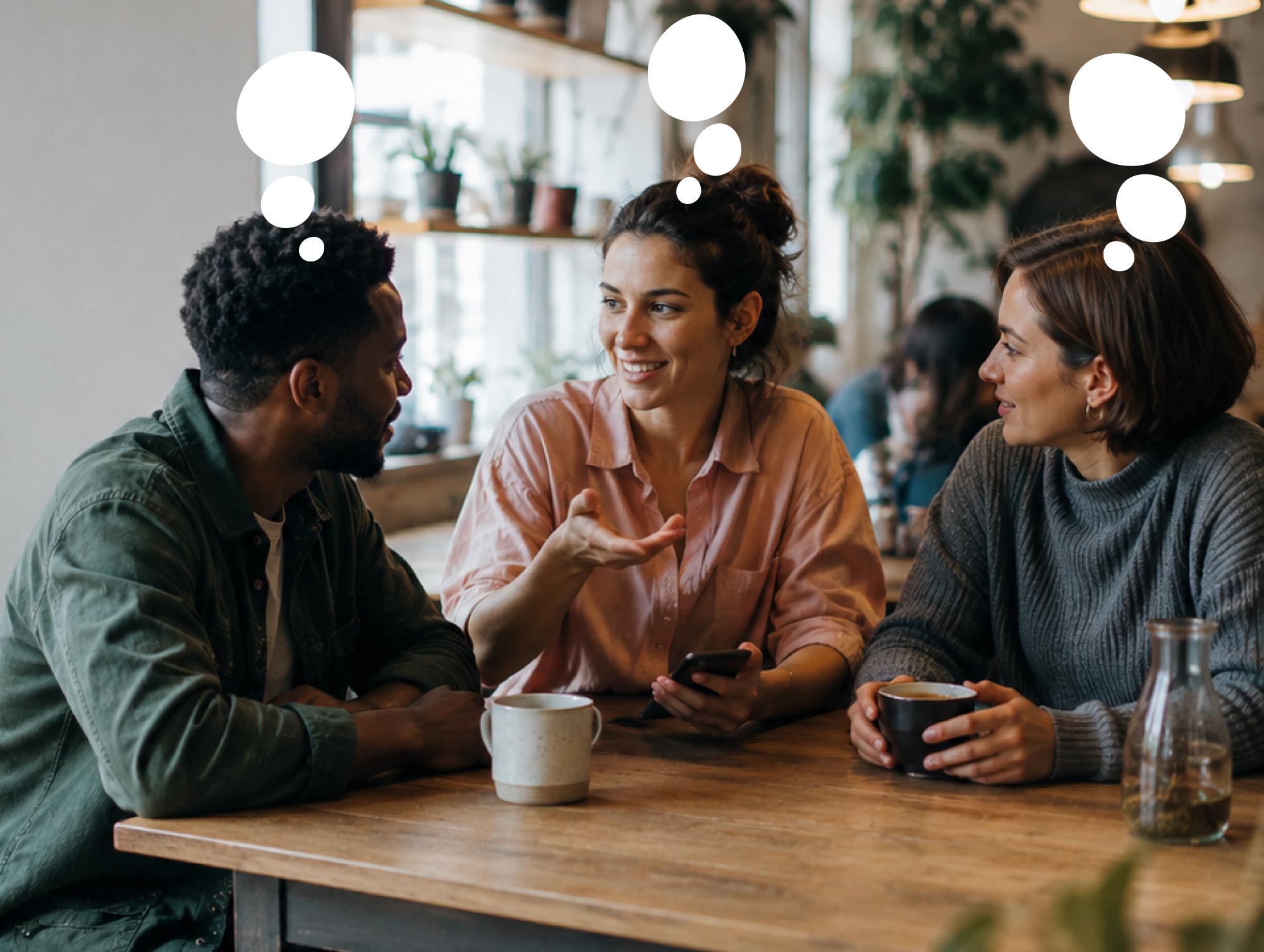 Three people sharing ideas together in a café